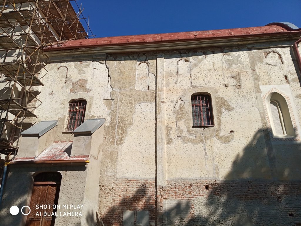 Pohľad na južnú  fasádu lode kostola s nálezmi  zo všetkých slohových období, archív KPÚ Nitra